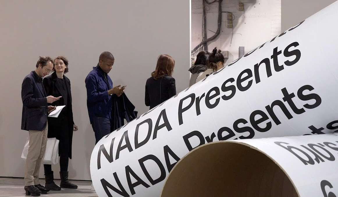 Nada Art Fair with people queueing behind a large rolled banner